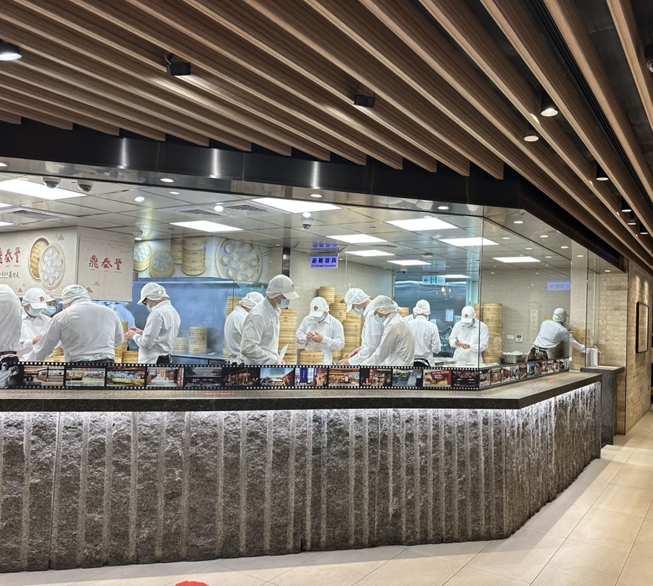 Chefs making dumplings behind the glass kitchen at Din Tai Fung in Taipei